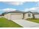 New construction home with a two-car garage and neatly landscaped yard at 1325 Oak Valley Dr, Auburndale, FL 33823