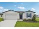 One-story home with gray siding, blue shutters, and a two-car garage at 1724 Forest Run Ln, Auburndale, FL 33823