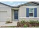 Inviting front entrance with a navy blue door, stone accents, and landscaping at 1724 Forest Run Ln, Auburndale, FL 33823