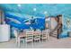 Dining area with ocean mural and stairs to upper level at 2734 Oxymoron Way, Kissimmee, FL 34746