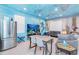 Living area with ocean mural, gray sofa and dining table at 2734 Oxymoron Way, Kissimmee, FL 34746
