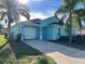 Single-story home with attached garage and light teal exterior at 345 Reserve Dr, Davenport, FL 33896