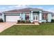 Light blue one-story house with a two-car garage and landscaped yard at 6019 Live Oak Dr, Winter Haven, FL 33880