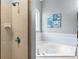 Bathroom with shower and corner bathtub, a window, and decorative wall art at 6019 Live Oak Dr, Winter Haven, FL 33880