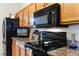 Modern kitchen with granite countertops, black appliances, and oak cabinets at 6019 Live Oak Dr, Winter Haven, FL 33880