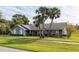 Gray house with stone accents, palm trees, and a well-manicured lawn at 653 Pelican Bay Dr, Daytona Beach, FL 32119