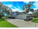 Two-car garage with a long driveway and lush landscaping at 6893 Hidden Glade Pl, Sanford, FL 32771