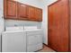 Bright laundry room, featuring wood cabinets and modern washer and dryer at 1562 Anorada Blvd, Kissimmee, FL 34744