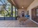 Large screened patio featuring a wooden dining table and comfortable seating area at 1562 Anorada Blvd, Kissimmee, FL 34744
