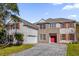 Two-story house with brick and stucco exterior, red door, and paver driveway at 3211 Eagle Watch Dr, Kissimmee, FL 34746