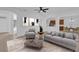 Spacious living room with gray sofa and chairs, coffee table, and view to kitchen at 3211 Eagle Watch Dr, Kissimmee, FL 34746