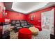 Home theater with red walls, black seating, and large screen at 1529 Corolla Ct, Reunion, FL 34747