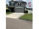 Two story house with gray siding, solar panels, and double car garage at 1952 Dunn Cove Dr, Apopka, FL 32703