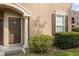 Building entry with brown door, columns, and shrubbery at 14304 Fredricksburg Dr # 420, Orlando, FL 32837