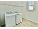 Bright laundry room with washer, dryer, and overhead shelving at 1652 Cross Prairie Pkwy, Kissimmee, FL 34744