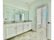 Double vanity bathroom with a large mirror and an adjacent bathtub at 1652 Cross Prairie Pkwy, Kissimmee, FL 34744