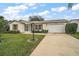 Beige one-story house with a two-car garage and landscaping at 2788 Privada Dr, The Villages, FL 32162