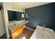 Bathroom with a bathtub, double vanity, and dark blue walls at 3001 Mandolin Dr, Kissimmee, FL 34744