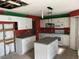 Kitchen with white cabinets, an island, and red walls at 3001 Mandolin Dr, Kissimmee, FL 34744