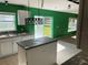 Kitchen with an island, white cabinets and green walls at 3001 Mandolin Dr, Kissimmee, FL 34744
