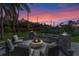 Evening view of fire pit area with seating and beautiful sunset at 9810 Camberley Cir, Orlando, FL 32836