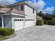 Two-car garage with paver driveway and landscaping at 9810 Camberley Cir, Orlando, FL 32836