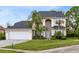 Two-story house with a large front yard, two car garage and palm trees at 2815 Crane Trace Cir, Orlando, FL 32837