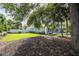Large backyard with grassy area, mature trees, and a pool at 5646 Masters Blvd, Orlando, FL 32819