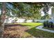 Landscaped backyard with a large tree providing shade at 5646 Masters Blvd, Orlando, FL 32819