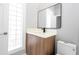 Clean bathroom with wood vanity, a modern sink and a glass block window at 5646 Masters Blvd, Orlando, FL 32819