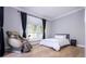 Bright bedroom with a massage chair, a queen-size bed, and hardwood floors at 5646 Masters Blvd, Orlando, FL 32819