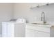 Bright laundry room with white cabinets and sink at 5646 Masters Blvd, Orlando, FL 32819