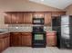 Kitchen with dark wood cabinets, granite counters and black appliances at 3651 N Goldenrod Rd # 208E, Winter Park, FL 32792