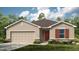 Exterior view of a single-story home with a two-car garage and landscaping at 638 Teviot Rd, Haines City, FL 33844