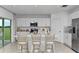 Modern kitchen with island, white cabinets, stainless steel appliances, and breakfast bar at 638 Teviot Rd, Haines City, FL 33844