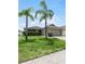 One-story house with a two-car garage, palm trees and well-maintained lawn at 806 Knightsbridge Cir, Davenport, FL 33896