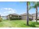 One-story house with a two-car garage, palm trees and well-maintained lawn at 806 Knightsbridge Cir, Davenport, FL 33896