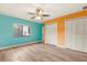 Bright bedroom with teal accent wall, ceiling fan, and large closet at 9792 Wild Oak Dr, Windermere, FL 34786