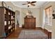 Home office with hardwood floors, built-in shelving, and a comfortable sitting area at 10193 Pointview Ct, Orlando, FL 32836