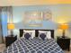 Primary bedroom with king-size bed, nightstands and wall art at 1572 Flange Dr, Davenport, FL 33896