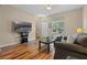 Living room with hardwood floors, gray sofa, and large TV at 506 Rainbow Springs Loop, Groveland, FL 34736