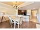 Bright dining area with white table and chairs, hardwood floors, and a view of the kitchen at 7612 Cabana Ct # 303, Reunion, FL 34747