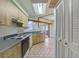 A galley kitchen with wood cabinets, and a view into a screened porch at 2763 E Waco Dr, Deltona, FL 32738