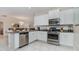 Well-equipped kitchen featuring white cabinets and stainless steel appliances at 5160 Oakbourne Ave, Davenport, FL 33837