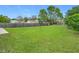Large backyard with grassy lawn, wooden fence, and mature trees at 7471 Crooked Lake Cir, Orlando, FL 32818