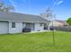 Home's backyard with patio, grill, and fenced-in grassy yard at 7471 Crooked Lake Cir, Orlando, FL 32818