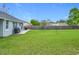 Backyard view showcasing a patio, grill, and grassy area at 7471 Crooked Lake Cir, Orlando, FL 32818