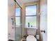 Clean bathroom featuring a shower, toilet, and window at 7471 Crooked Lake Cir, Orlando, FL 32818