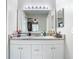 Bathroom vanity with granite countertop, white cabinets, and a large mirror at 7471 Crooked Lake Cir, Orlando, FL 32818
