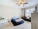 Bedroom with a bed, lounger, dresser, and large window at 7471 Crooked Lake Cir, Orlando, FL 32818